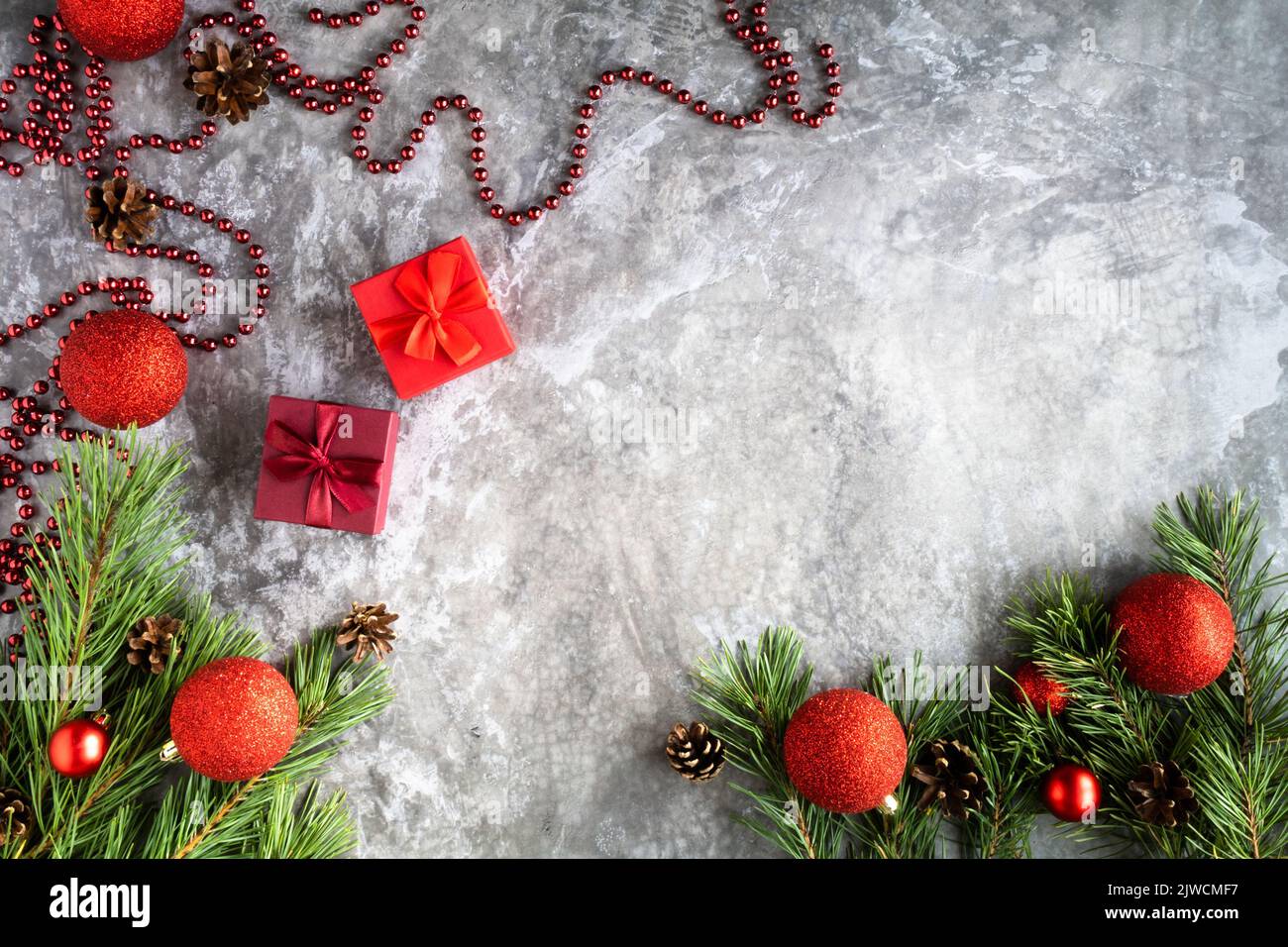 Zweige eines Weihnachtsbaums mit Zapfen, Weihnachtskugeln, auf einem hellen Hintergrund.Draufsicht. Perfekte Weihnachten Hintergrund Stockfoto