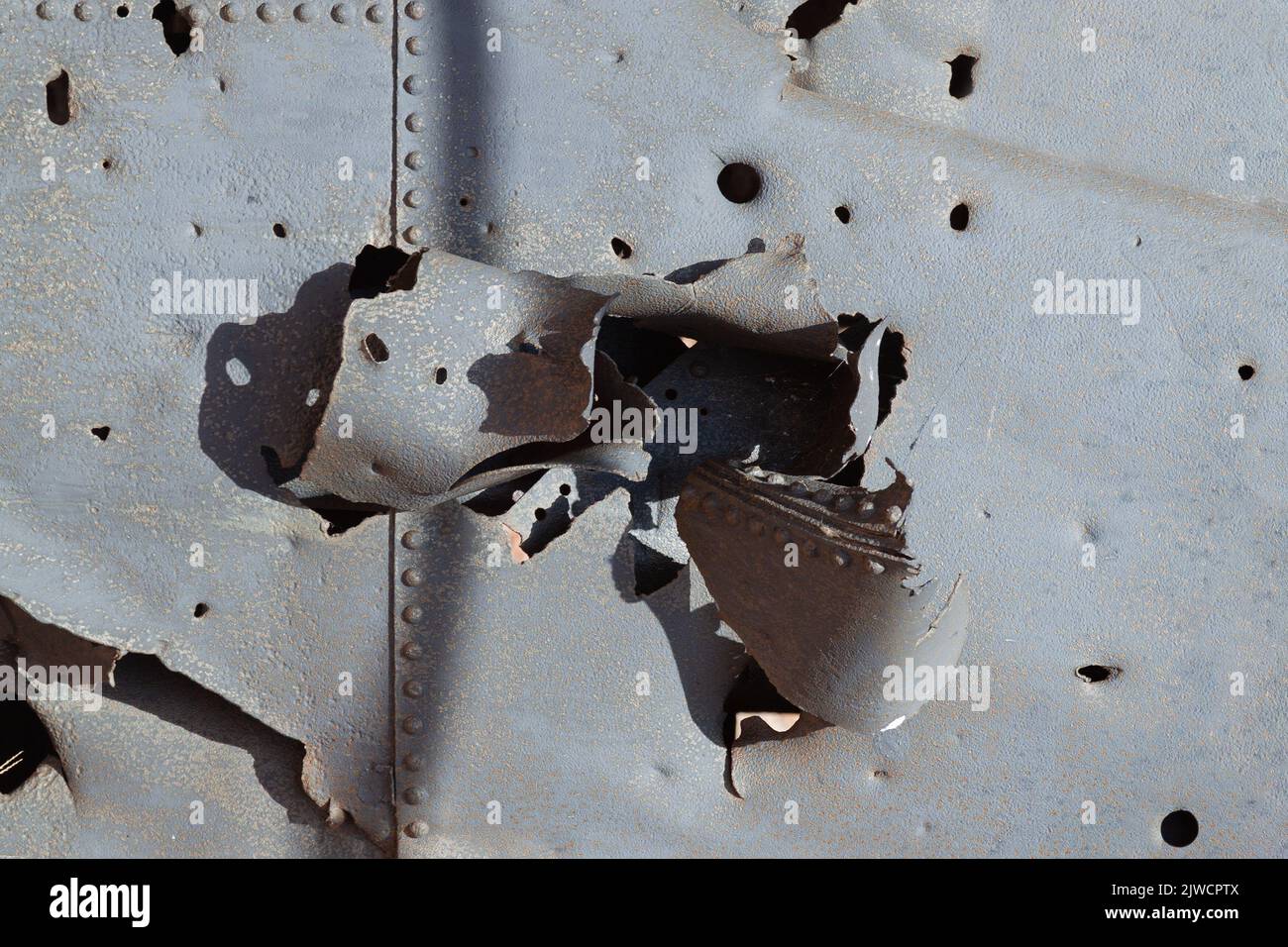 Stahlblech, durchbohrt von einer Artilleriebgranate. Stockfoto