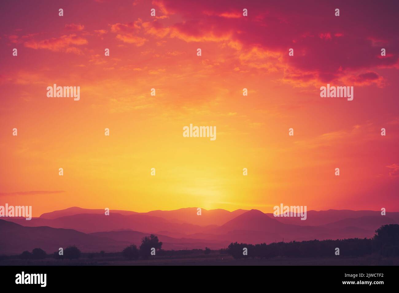 Erstaunlicher leuchtend orangefarbener Sonnenuntergang über der Bergkette. Schöne Naturkulisse Hintergrund. Bild des Tourismus- und Reisekonzepts. Speicherplatz kopieren. Stockfoto