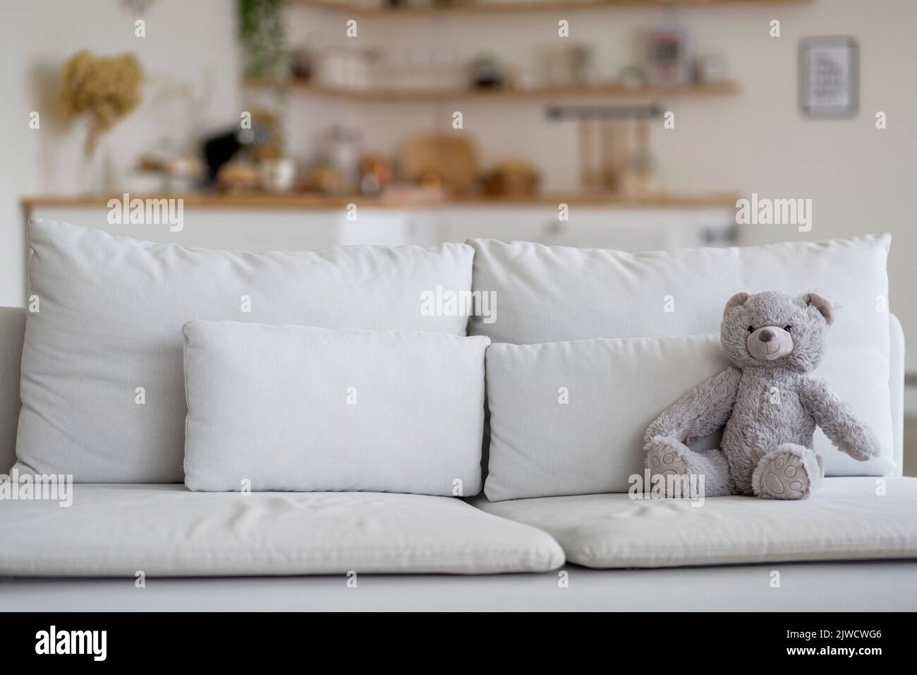 Teddybär sitzt auf dem Sofa im Wohnzimmer Stockfoto