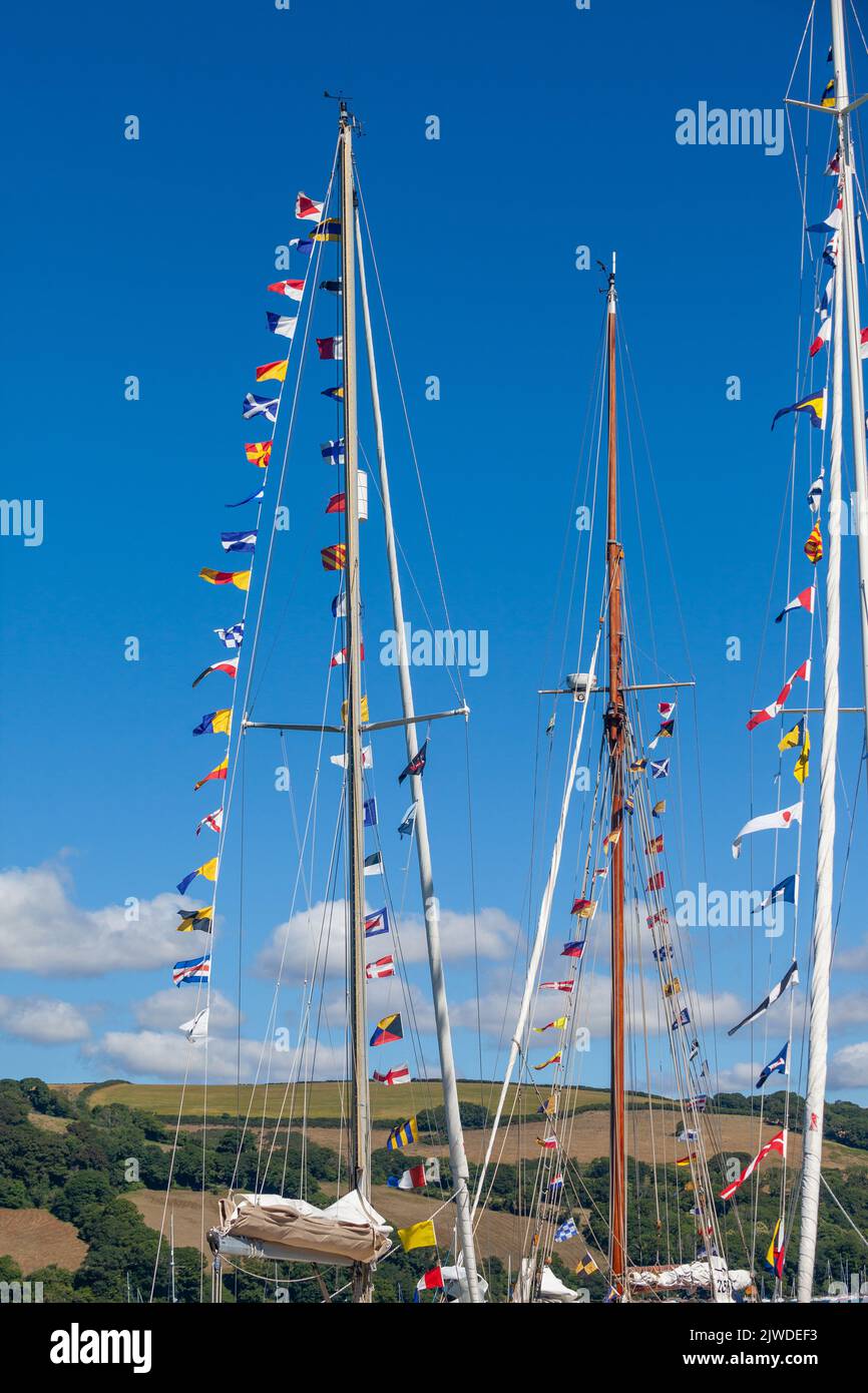 Eine Sammlung internationaler Flaggen, die von einem Mast eines klassischen Segelbootes fliegen Stockfoto