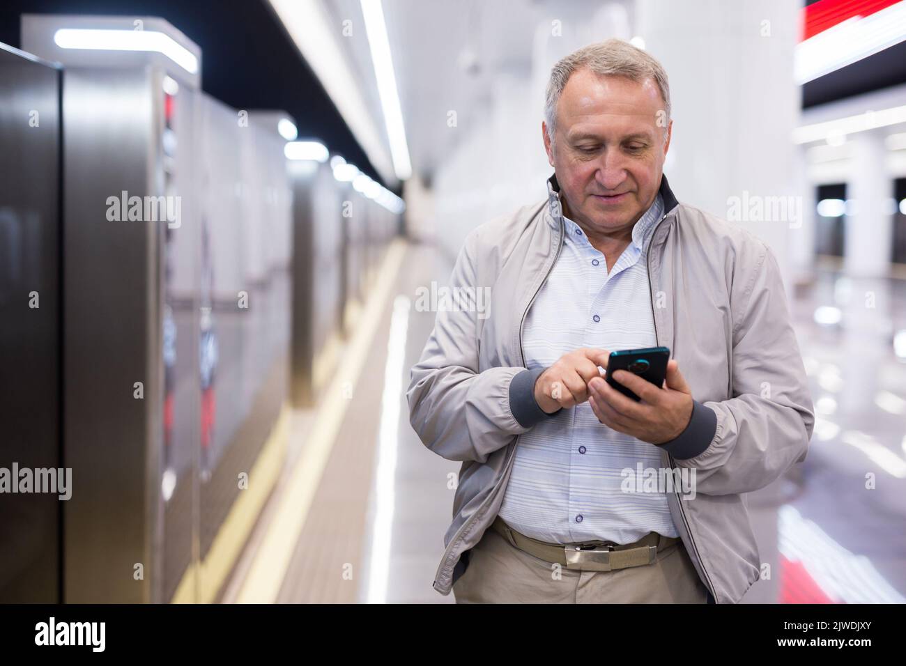 Mann mittleren Alters, der in der U-Bahn-Station auf den Zug wartet Stockfoto
