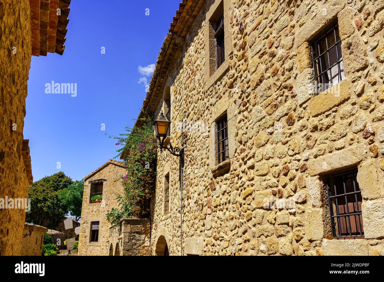 Fassaden von alten Häusern aus Stein mit versperrten Fenstern und Holztüren, Pals, Girona. Stockfoto
