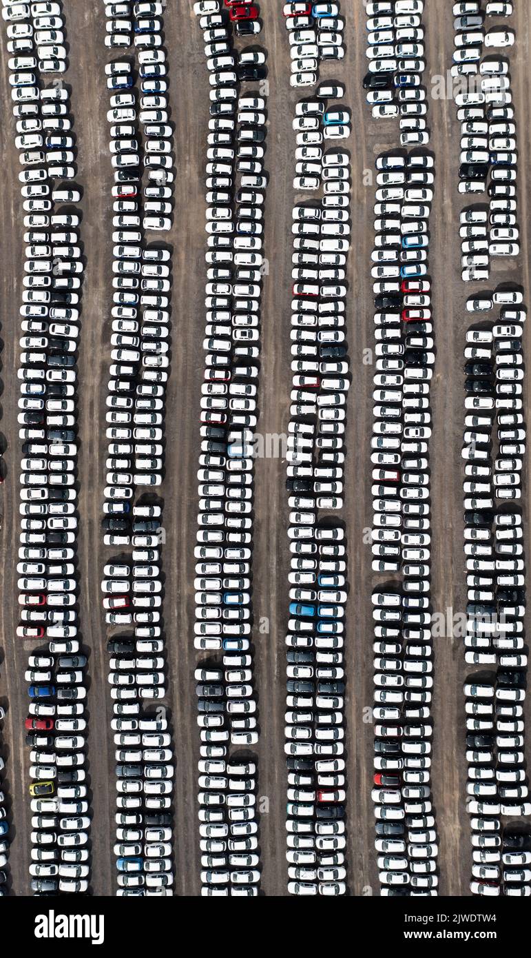 Eine Luftaufnahme von Reihen von neu gebauten Autos und Fahrzeugen bereit für den Export und Import und Lieferung an Verkaufshändler auf einem Hafen oder Terminal Dock Stockfoto