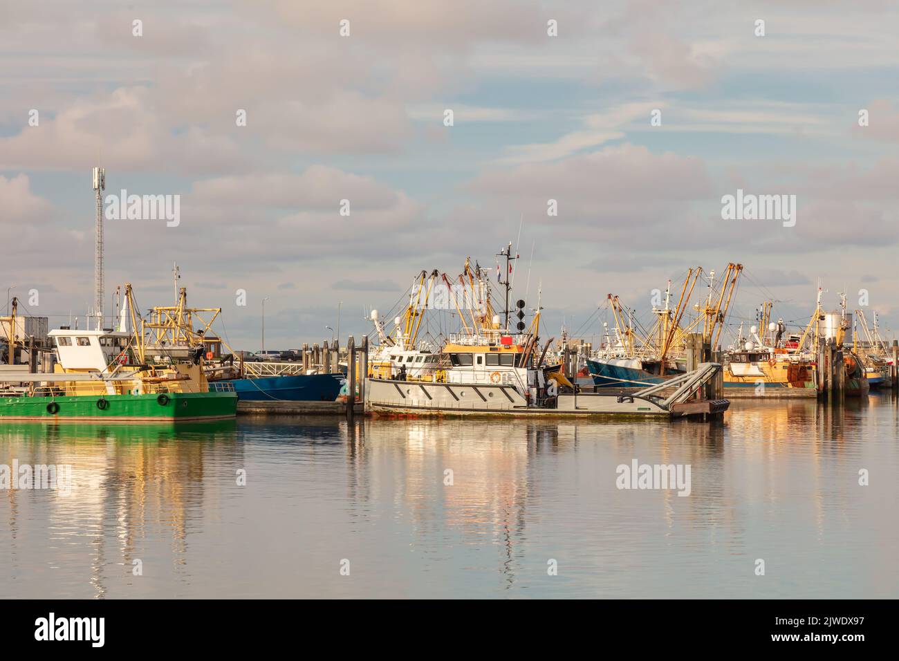 Niederländische Fischerboote bei Sonnenuntergang im Hafen von Lauwersoog in Friesland, Niederlande Stockfoto
