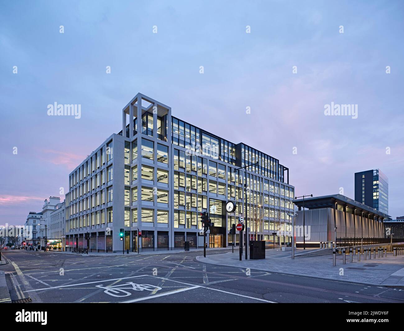 Kreuzung bei 50 Eastbourne Terrace in der Abenddämmerung. 50 Eastbourne Terrace, London, Großbritannien. Architekt: Sheppard Robson, 2021. Stockfoto