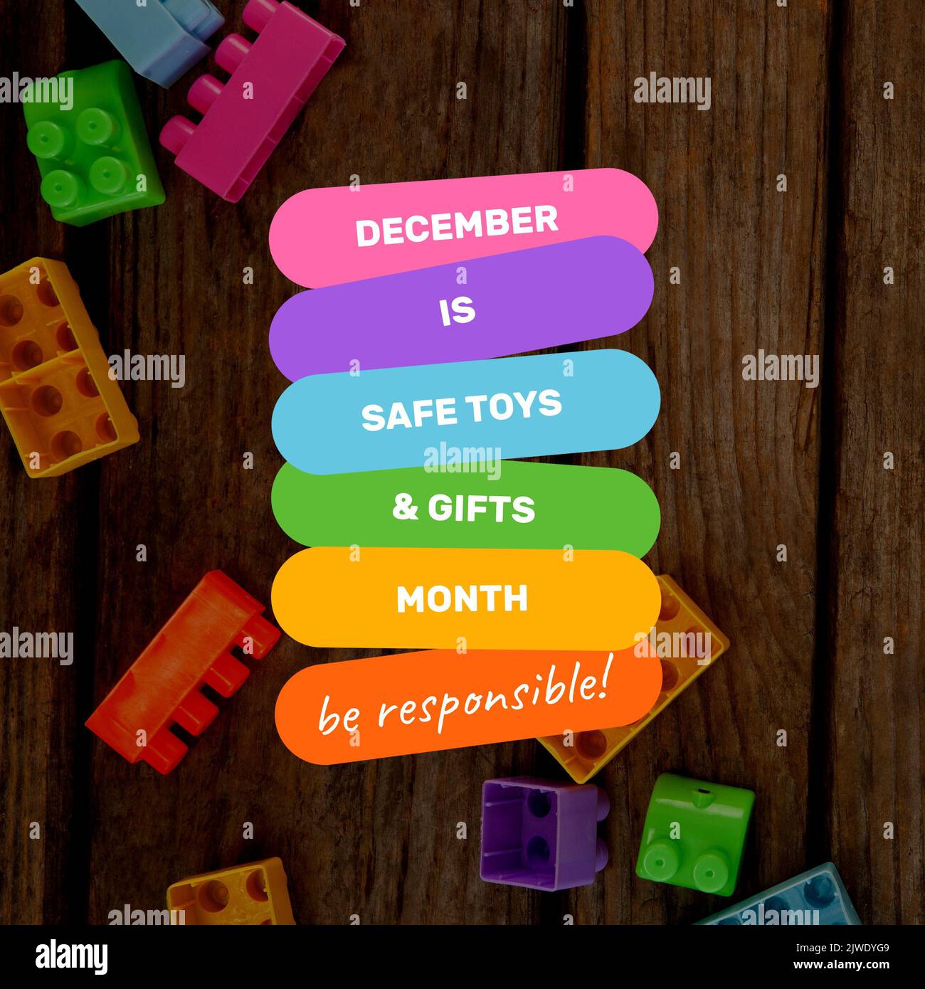 Dezember ist ein sicherer Spielzeug- und Geschenkmonat mit verantwortbarem Text über bunten Spielzeugblöcken auf dem Tisch Stockfoto