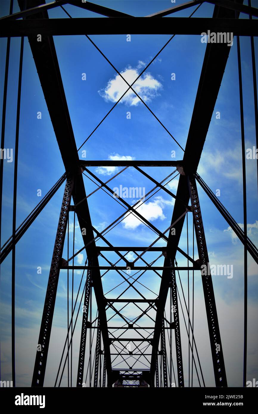 Ein niedriger Winkel Aufnahme einer Brücke mit Metallstützen gegen einen bewölkten Himmel Stockfoto