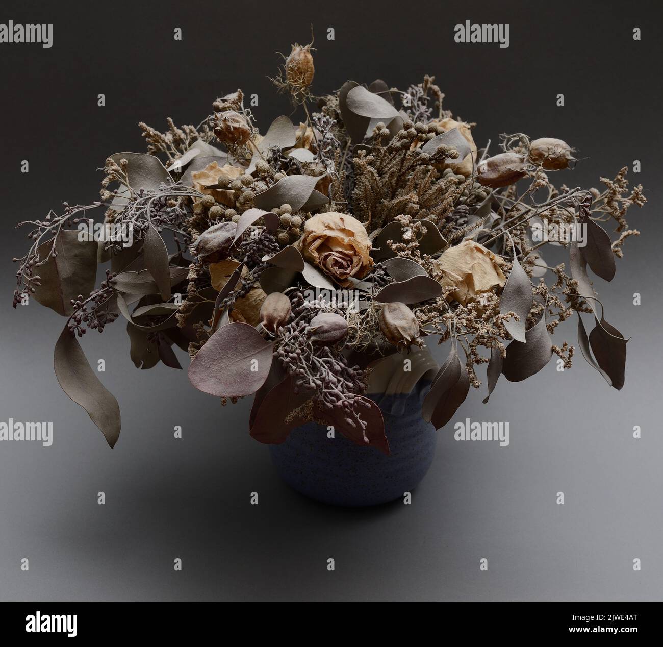 Bouquet von getrockneten Blumen in Keramikvase auf neutralem Hintergrund Stockfoto
