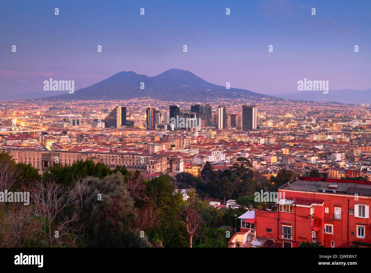 Neapel, Italien mit der Skyline des Finanzviertels unter dem Berg Vesuv in der Dämmerung. Stockfoto