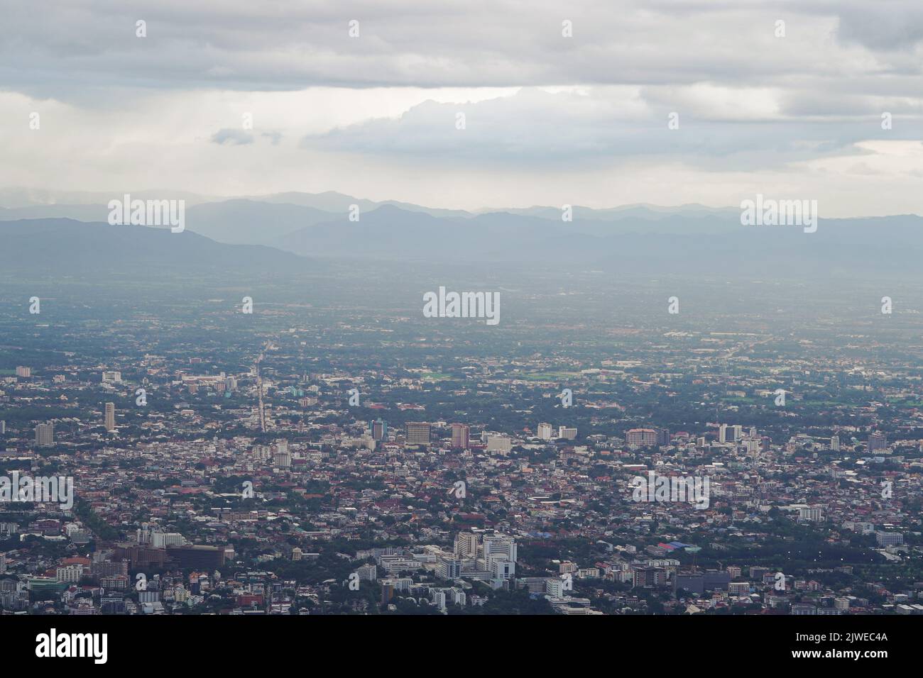 Blick von oben auf den Berg in Chiang Mai City, Thailand. Weiße Wolken und Staub sind über dem Berg, während Städte weit entfernt zu sehen sind. Stockfoto