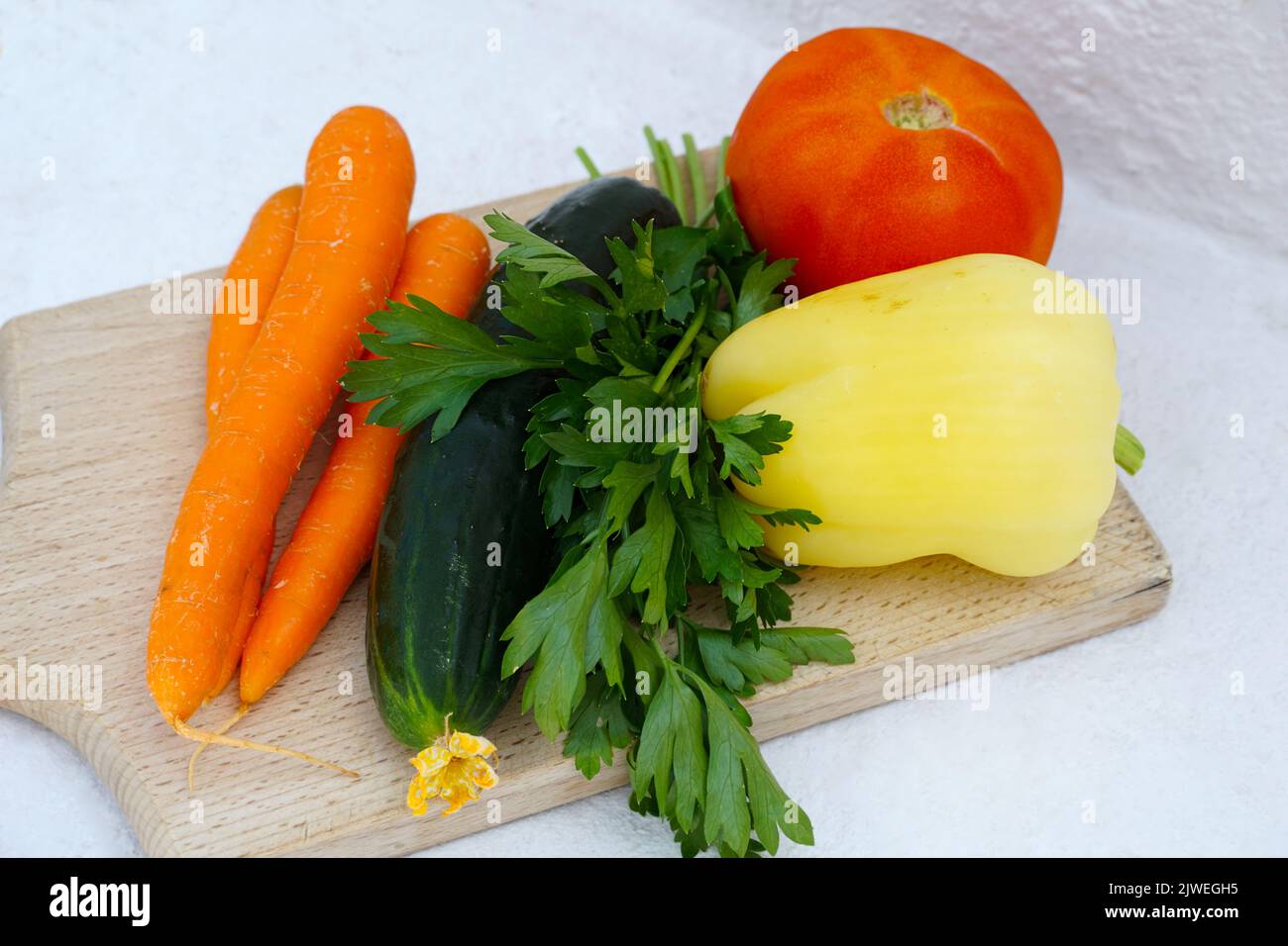 Ein Haufen aus frischem, biologisch angebautem Gemüse, Karotten, Gurken, Petersilienblatt, gelbem Pfeffer und Tomaten Stockfoto