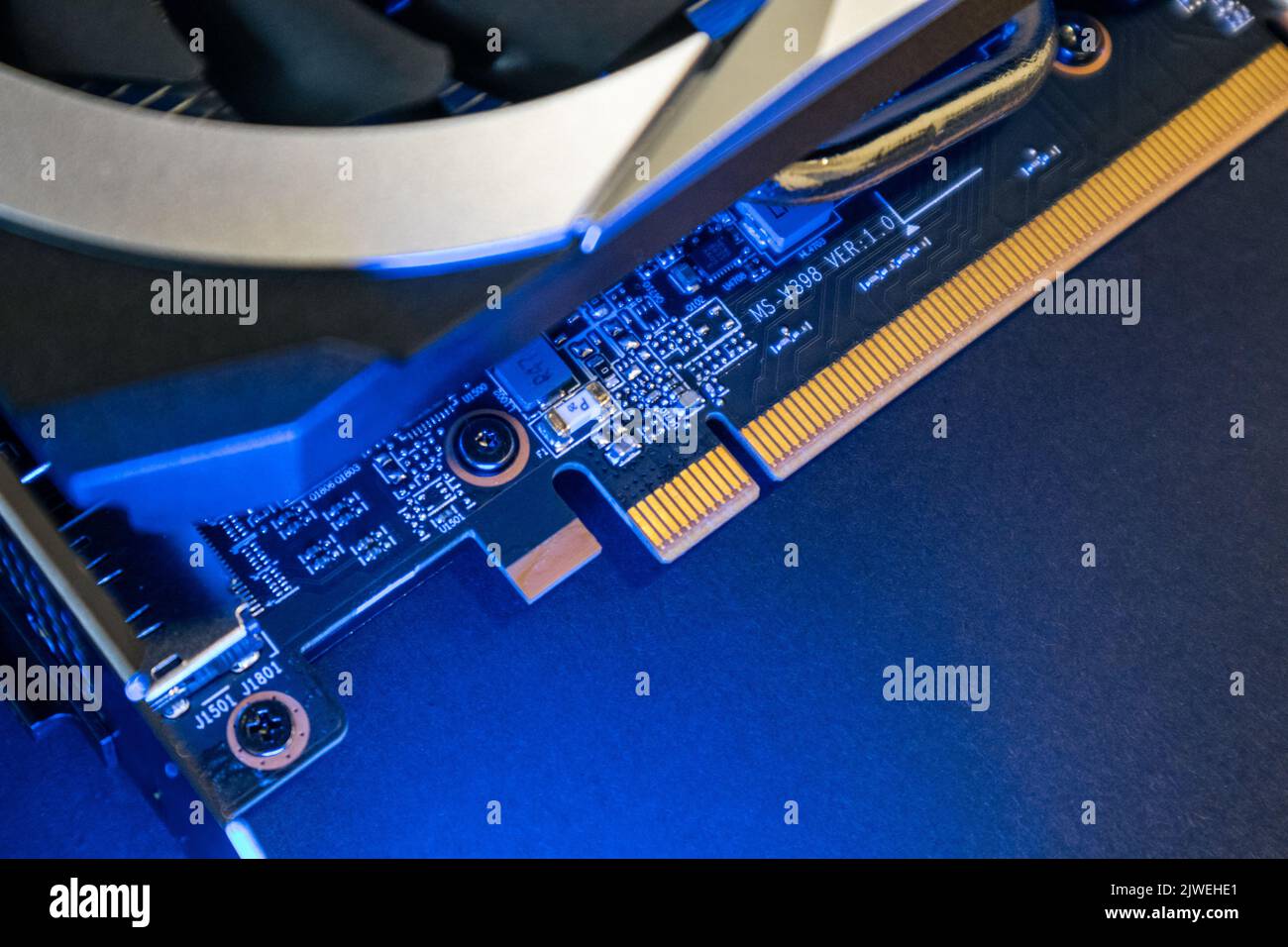 GPU-Grafik oder Grafikkarte goldene Kontakte Panel-Chip close-up in blauem Licht, PC-Hardware-Elektronik Details, Komponenten von leistungsstarken Computer Stockfoto