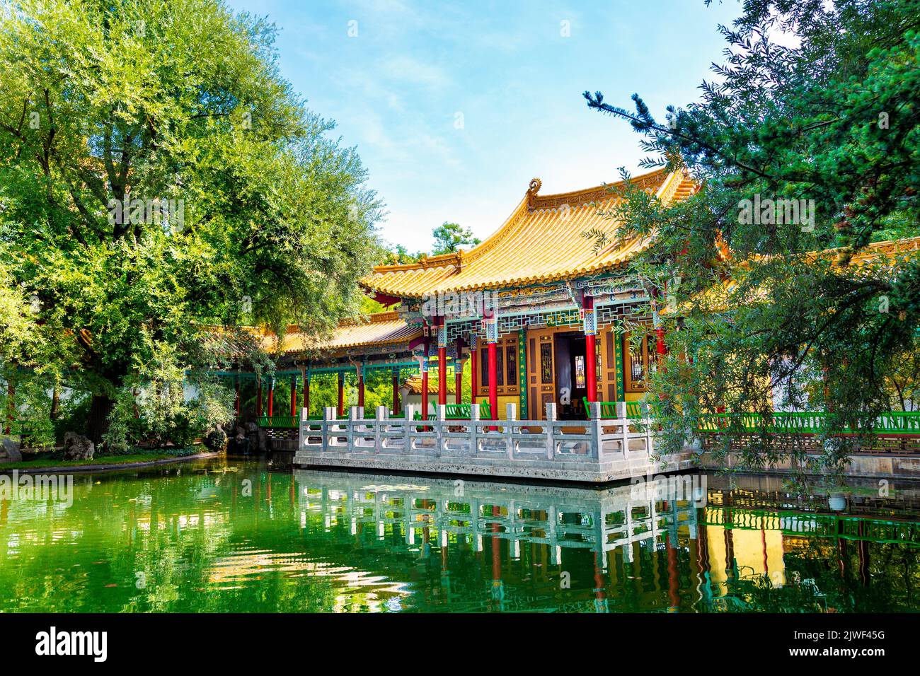 Farbenfroher chinesischer Pavillon mit Blick auf einen Teich im China Garden (Chinagarten Zürich), Seefeld, Zürich, Schweiz Stockfoto