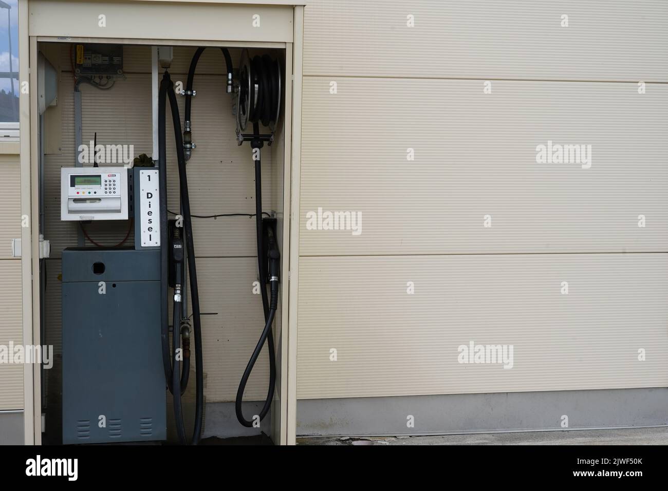 Diesel-Tankstelle in der Wand des cremefarbenen Industriegebäudes zum Nachfüllen aller Güter-Lkw. Stockfoto