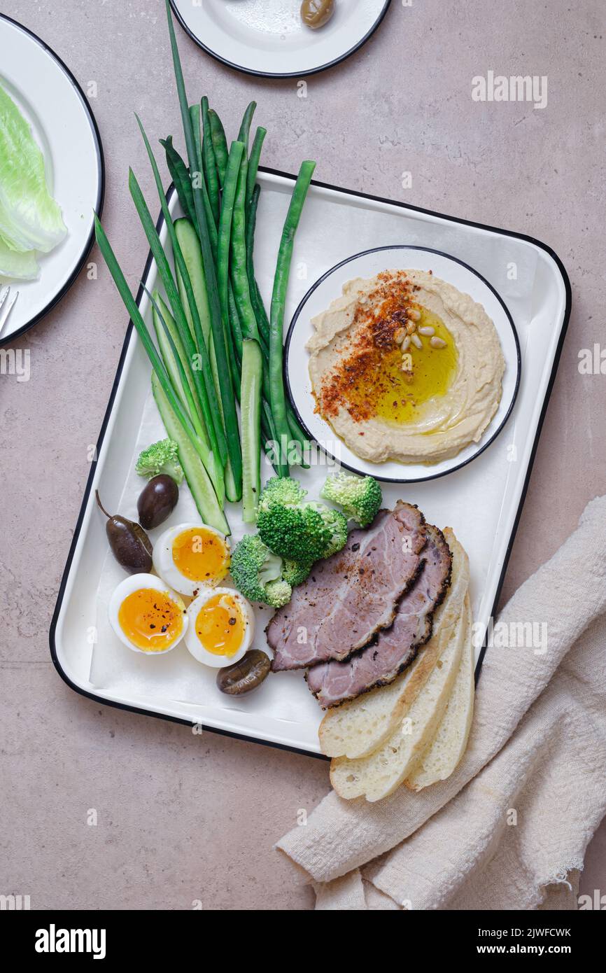 Frühstück mit hinterem Fleisch, Hummus und grünem Gemüse, Kopierplatz Stockfoto