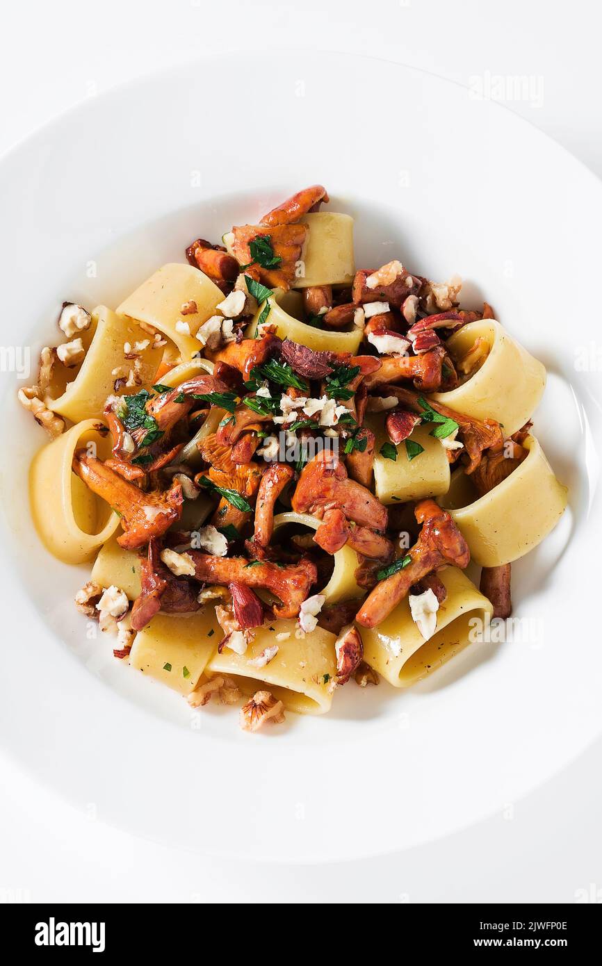 Pasta mit Pfifferlingen auf einem Teller auf dem Tisch Stockfoto