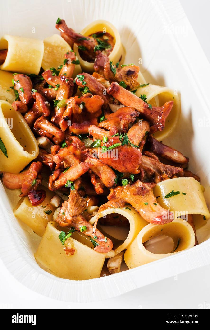 Pasta mit Pfifferlingen in einem Plastikbehälter zum Mitnehmen Stockfoto