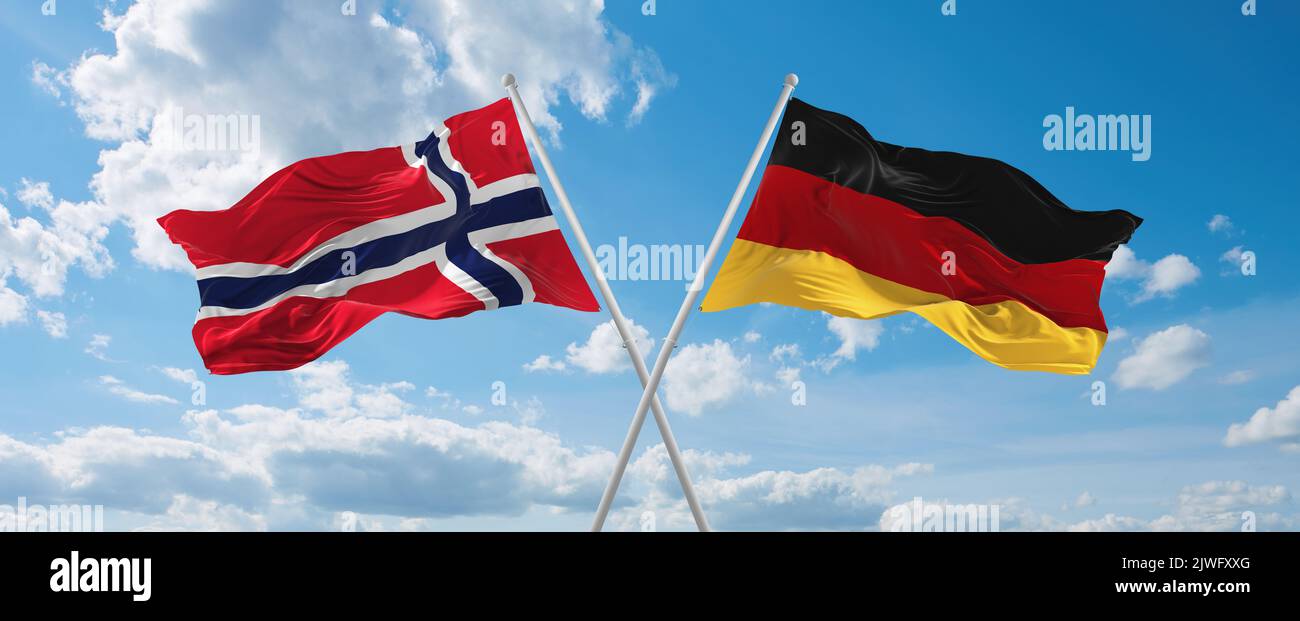 Zwei gekreuzte Flaggen Bundesrepublik Deutschland und Norwegen winken im Wind bei bewölktem Himmel. Konzept von Beziehung, Dialog, Reisen zwischen zwei Countri Stockfoto