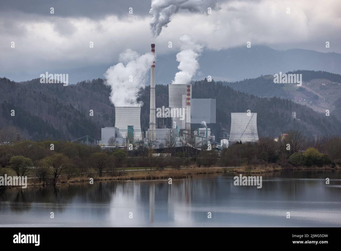 Der schwere graue Himmel über dem thermischen Kraftwerk raucht Rauch und Smog aus und verbrennt Kohle, die die Luft verschmutzt Stockfoto