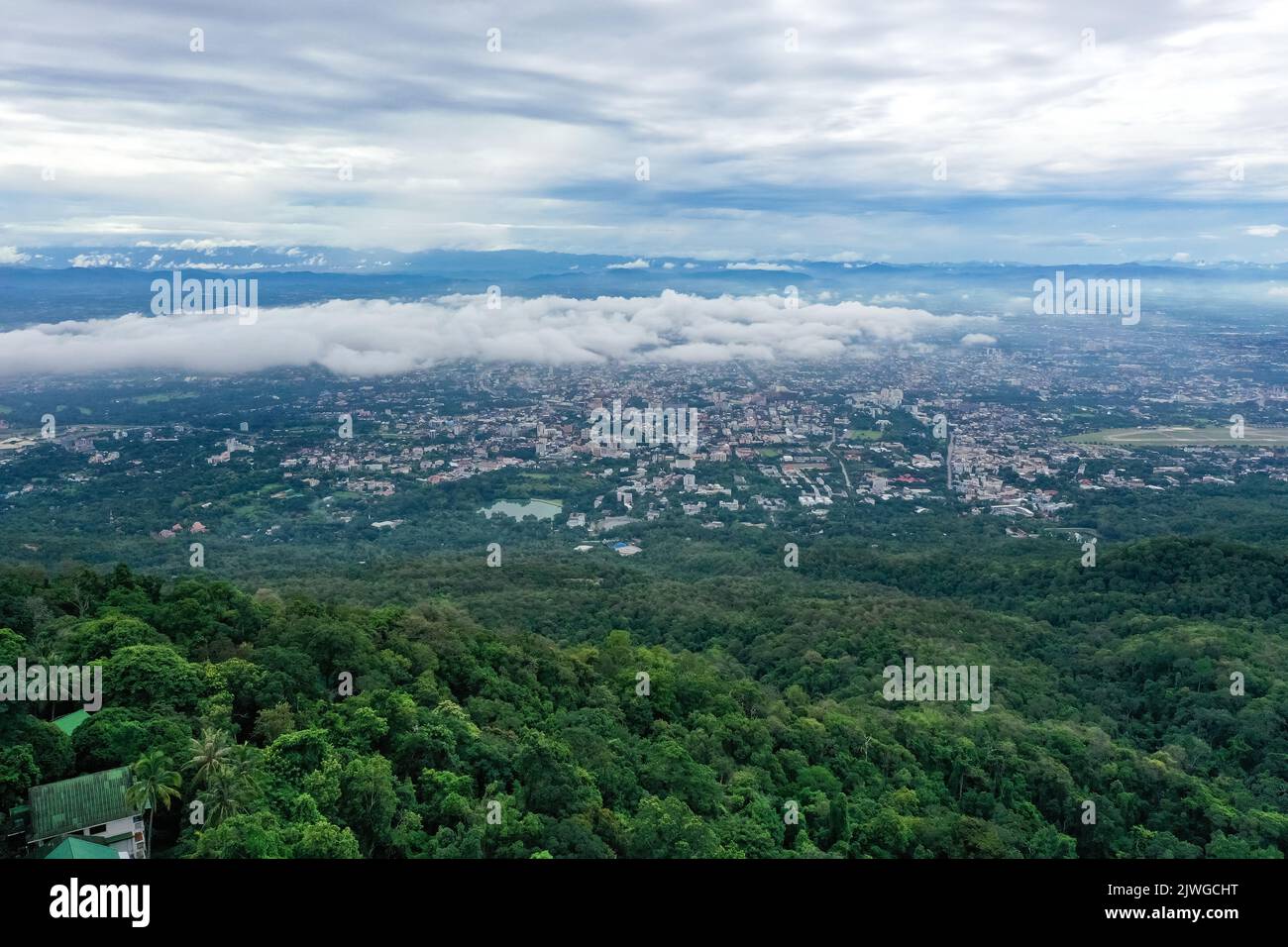 Blick von oben auf den Berg in Chiang Mai City, Thailand. Weiße Wolken und Staub sind über dem Berg, während Städte weit entfernt zu sehen sind. Stockfoto