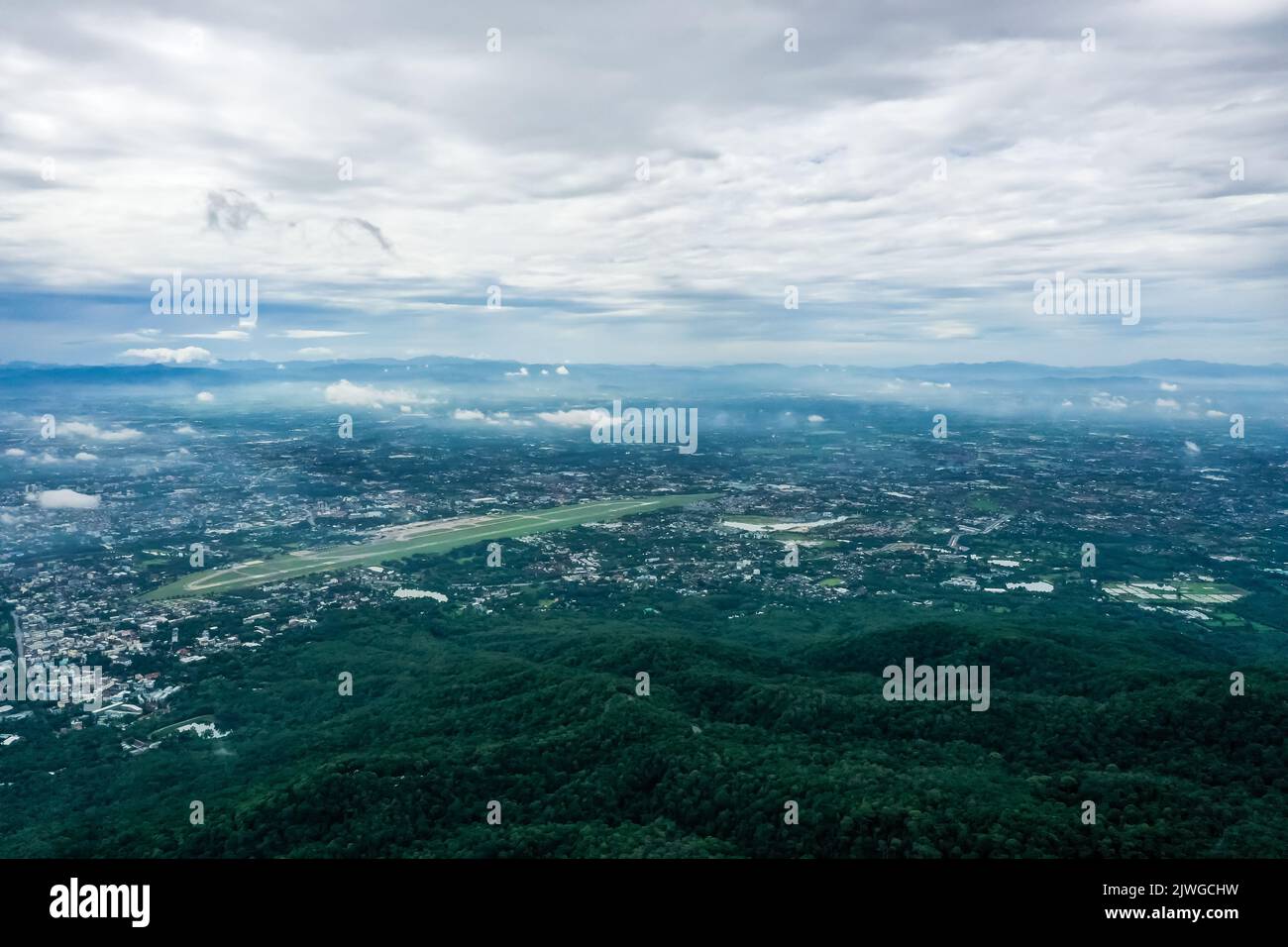 Blick von oben auf den Berg in Chiang Mai City, Thailand. Weiße Wolken und Staub sind über dem Berg, während Städte weit entfernt zu sehen sind. Stockfoto