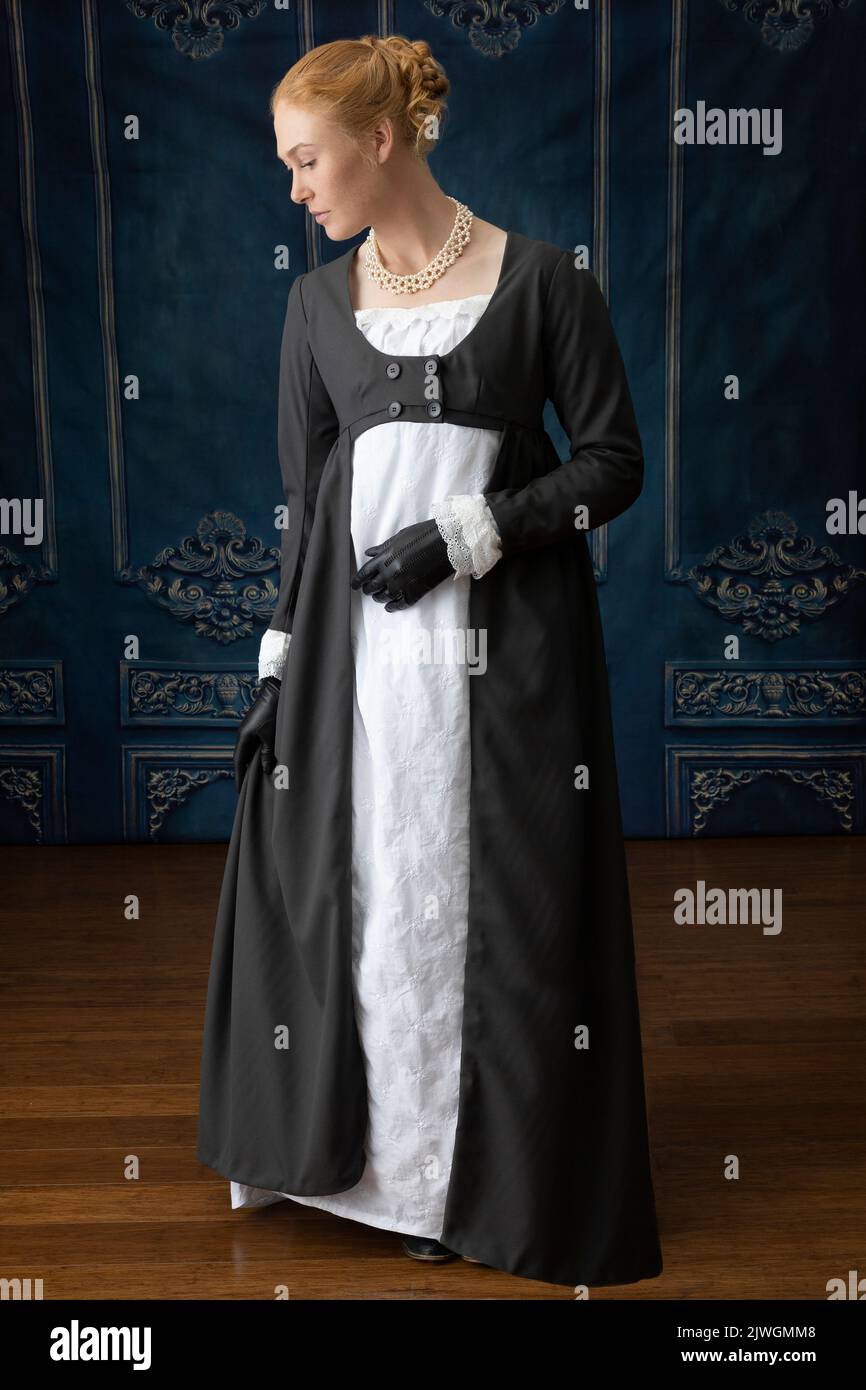 Eine Regency-Frau, die ein weißes, besticktes Musselin-Kleid mit einem langen spencer über der Oberseite trägt Stockfoto