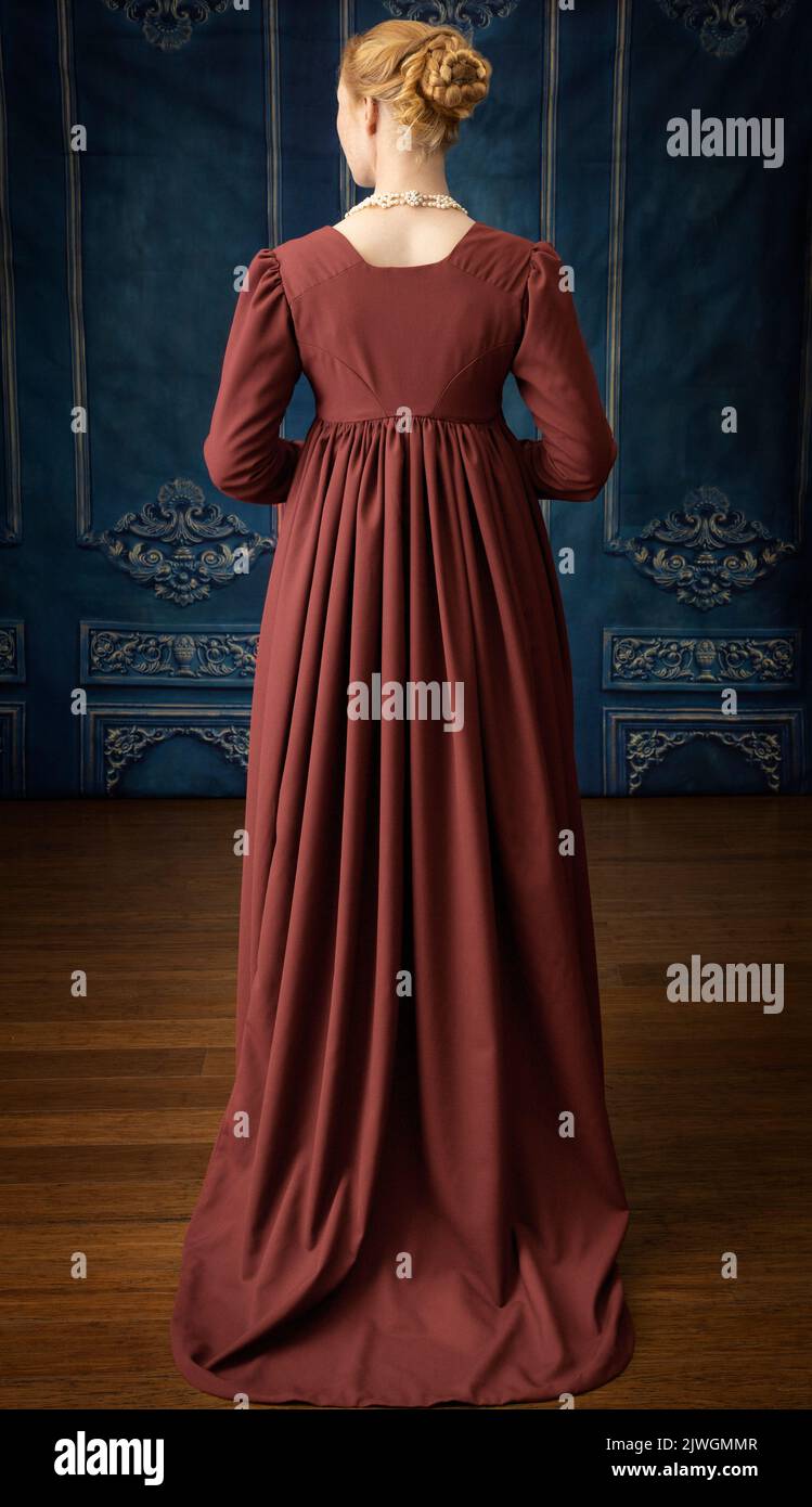 Eine Regency-Frau, die ein weißes, besticktes Musselin-Kleid mit einem langen spencer über der Oberseite trägt Stockfoto