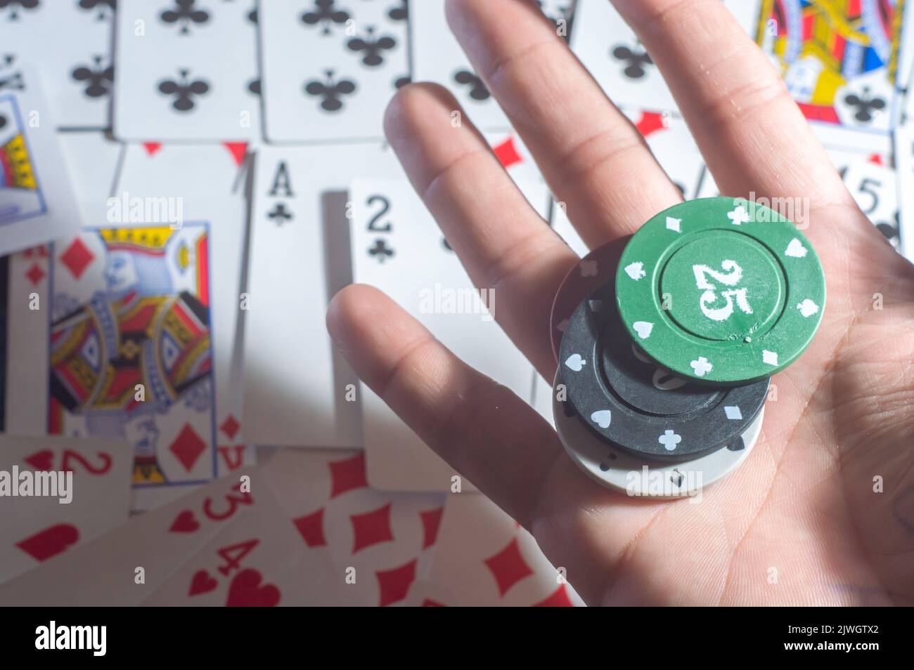Casino Karten Poker Blackjack, Hand hält Pokerchips mit Kopierraum und Deck Karte Hintergrund. Stockfoto