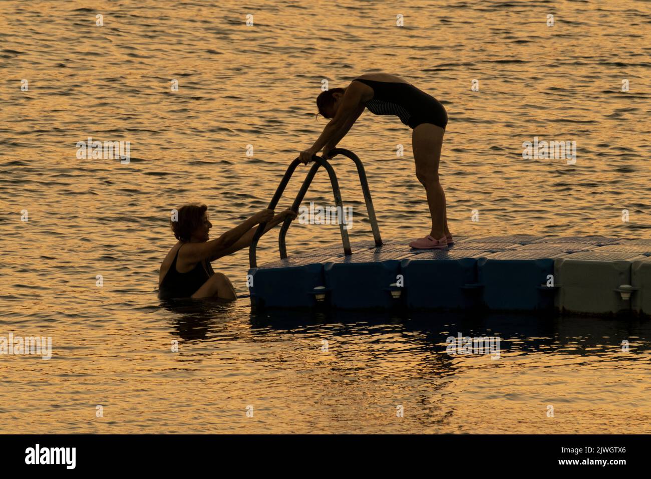 Zwei Damen Schwimmen Bei Sonnenuntergang Am Ägäischen Meer. Stockfoto