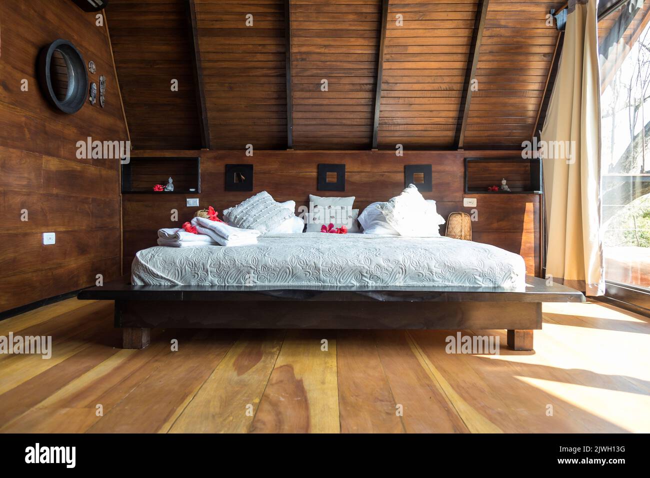 Großes Bett mit Handtüchern und Blumen in einem luxuriösen Hotelzimmer. Sehr gemütliche Atmosphäre. Urlaub Stockfoto