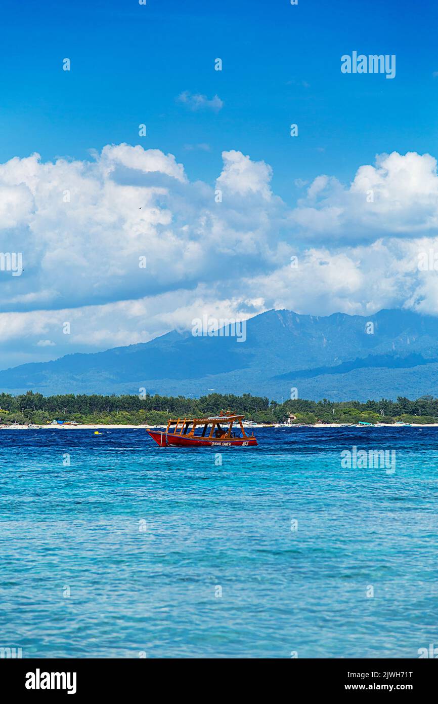 Bootstouren auf einem klaren und ruhigen türkisfarbenen Meer mit Wolken und Bergen im Hintergrund. Asiatisches Paradies Stockfoto