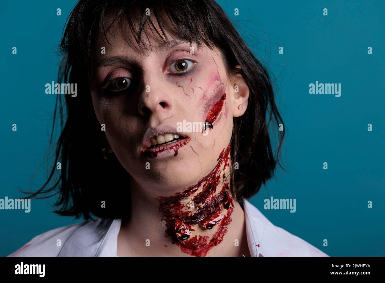 Portrait der gruseligen Zombie-Frau mit Kratzern, handeln gefährlich und grausam. Finstere apokalyptische Gehirn fressende Monster mit blutigen Narben und verwundeten Gesicht mit Blut. Nahaufnahme. Stockfoto