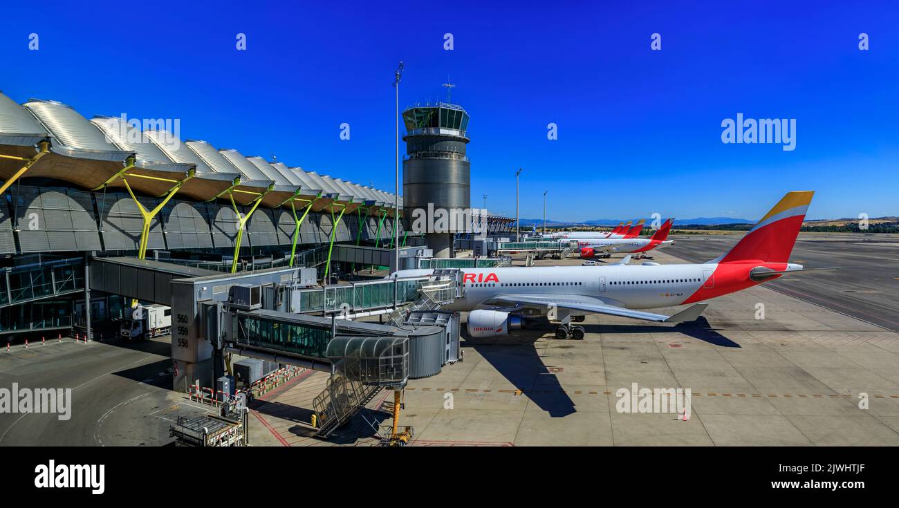 Madrid, Spanien - 28. Juni 2021: Moderne Architektur eines Terminals im internationalen Flughafen Madrid, Aeropuerto Madrid Barajas, MAD und eines Iberia-Flugzeugs Stockfoto