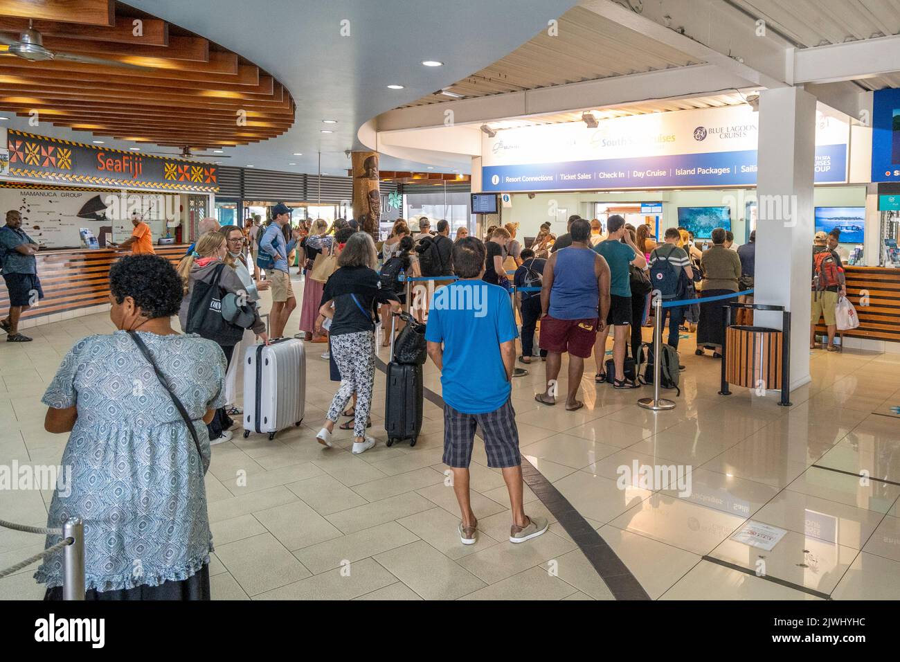 Touristen und Urlauber, die am Fährhafen Port Denarau, Nadi, Fidschi, Schlange stehen, um Tickets zu erhalten Stockfoto