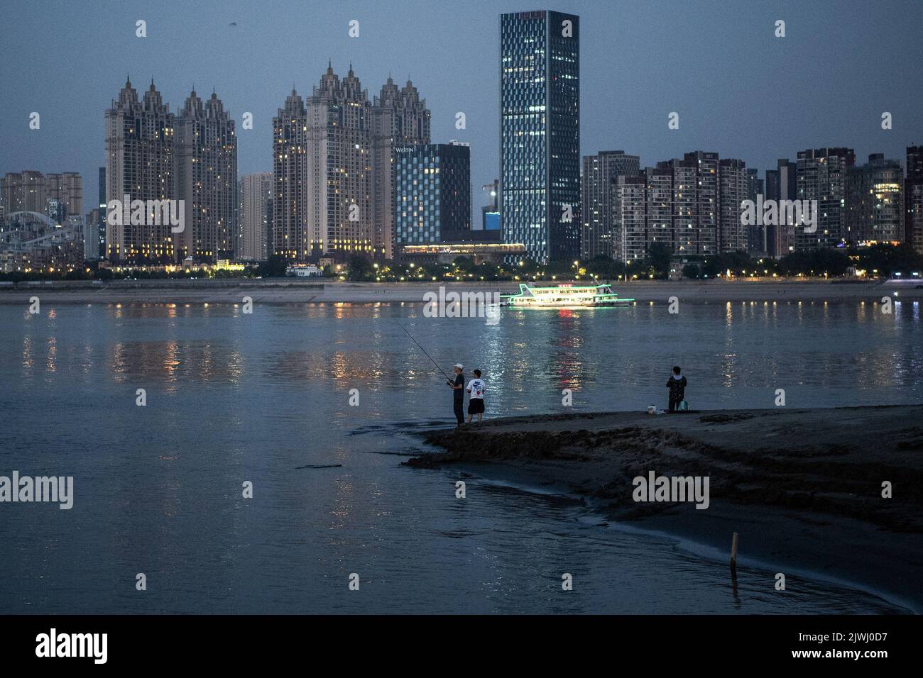 Wuhan, China. 05. September 2022. Männer sahen die Fischerei an den exponierten Ufern des Jangtse-Flusses. Eine Hitzewelle traf China im Sommer und beeinflussten die Nahrungsmittelproduktion, Fabriken, Stromversorgungen und den Transport erheblich. Die Hitzewelle hat auch den längsten Fluss Asiens, das Yangtse-Flussbecken, beeinflusst, was dazu führte, dass sein Wasserstand als der niedrigste seit Beginn der hydrologischen Aufzeichnungen im Jahr 1865 verzeichnet wurde. (Foto von Ren Yong/SOPA Images/Sipa USA) Quelle: SIPA USA/Alamy Live News Stockfoto