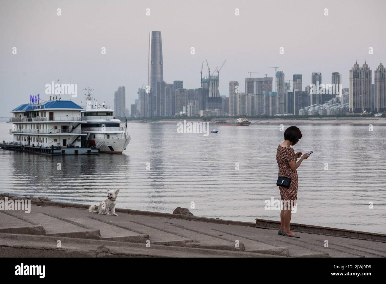 Wuhan, China. 05. September 2022. Eine Frau steht an den exponierten Ufern des Jangtse-Flusses. Eine Hitzewelle traf China im Sommer und beeinflussten die Nahrungsmittelproduktion, Fabriken, Stromversorgungen und den Transport erheblich. Die Hitzewelle hat auch den längsten Fluss Asiens, das Yangtse-Flussbecken, beeinflusst, was dazu führte, dass sein Wasserstand als der niedrigste seit Beginn der hydrologischen Aufzeichnungen im Jahr 1865 verzeichnet wurde. (Foto von Ren Yong/SOPA Images/Sipa USA) Quelle: SIPA USA/Alamy Live News Stockfoto