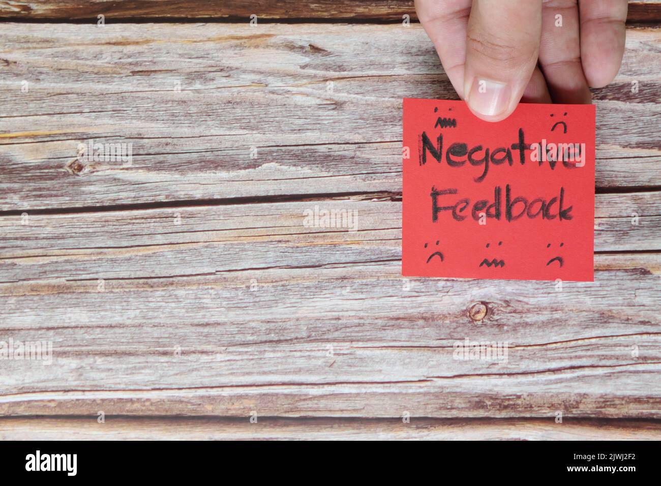 Umgang mit dem Konzept des negativen Kundenfeedbacks. Hand hält rote Notiz mit geschriebendem Wort mit Kopierraum. Stockfoto