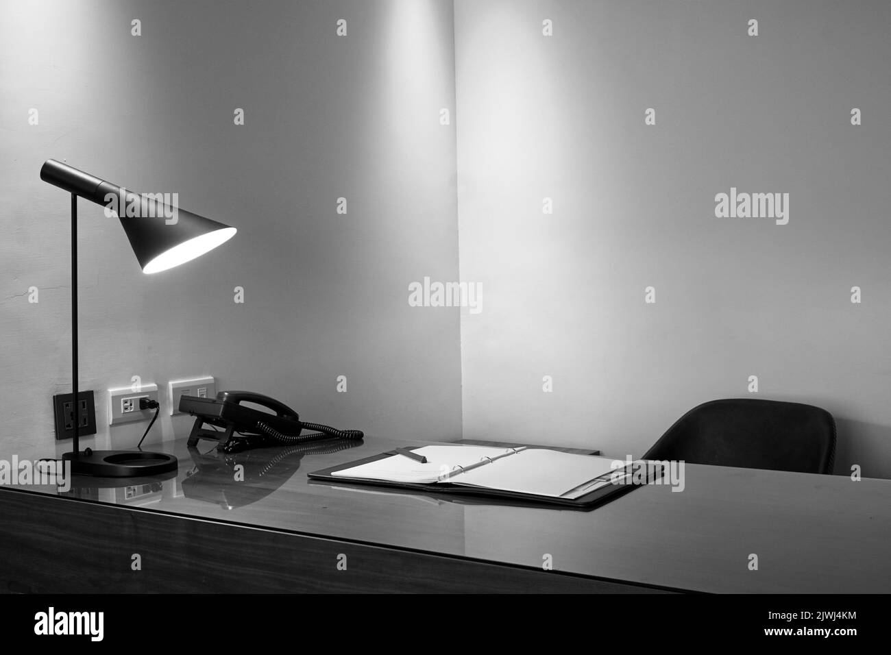 Lampe, Telefon und Notizbuch auf einem Schreibtisch in einem luxuriösen Büro Stockfoto