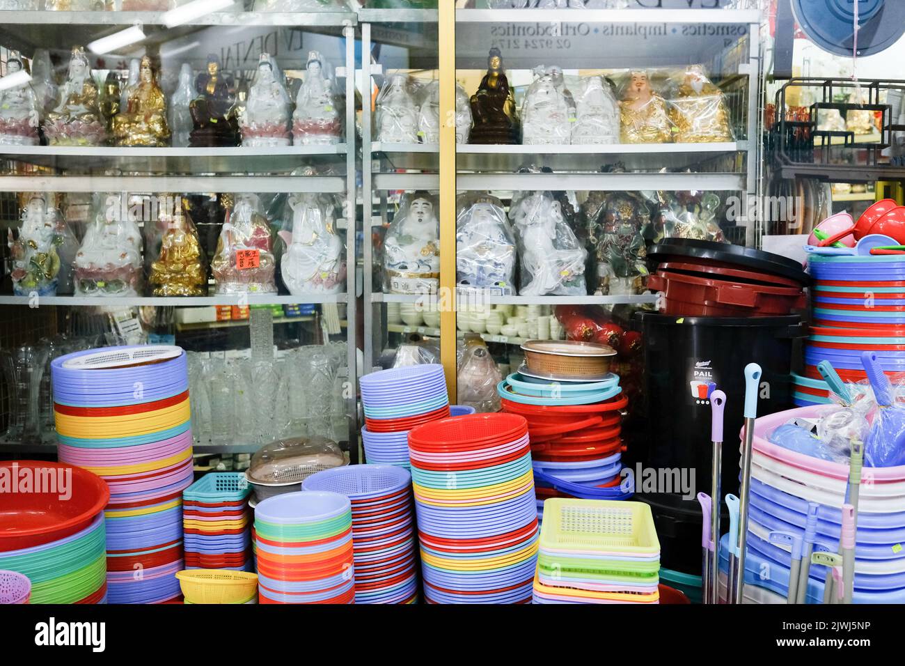 Buddha und Kwan Yin Statuen, bunte Kunststoff-Waschbecken zum Verkauf in einem vietnamesischen Geschäft in Cabramatta - Sydney, Australien Stockfoto