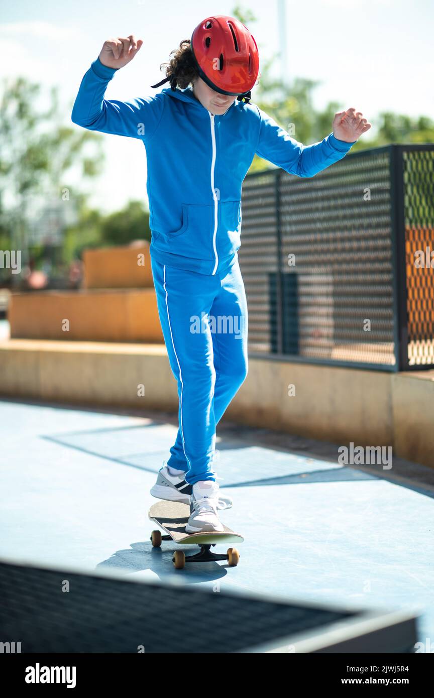 Teenager in einem Schutzhelm üben seine Skateboarding-Fähigkeiten Stockfoto
