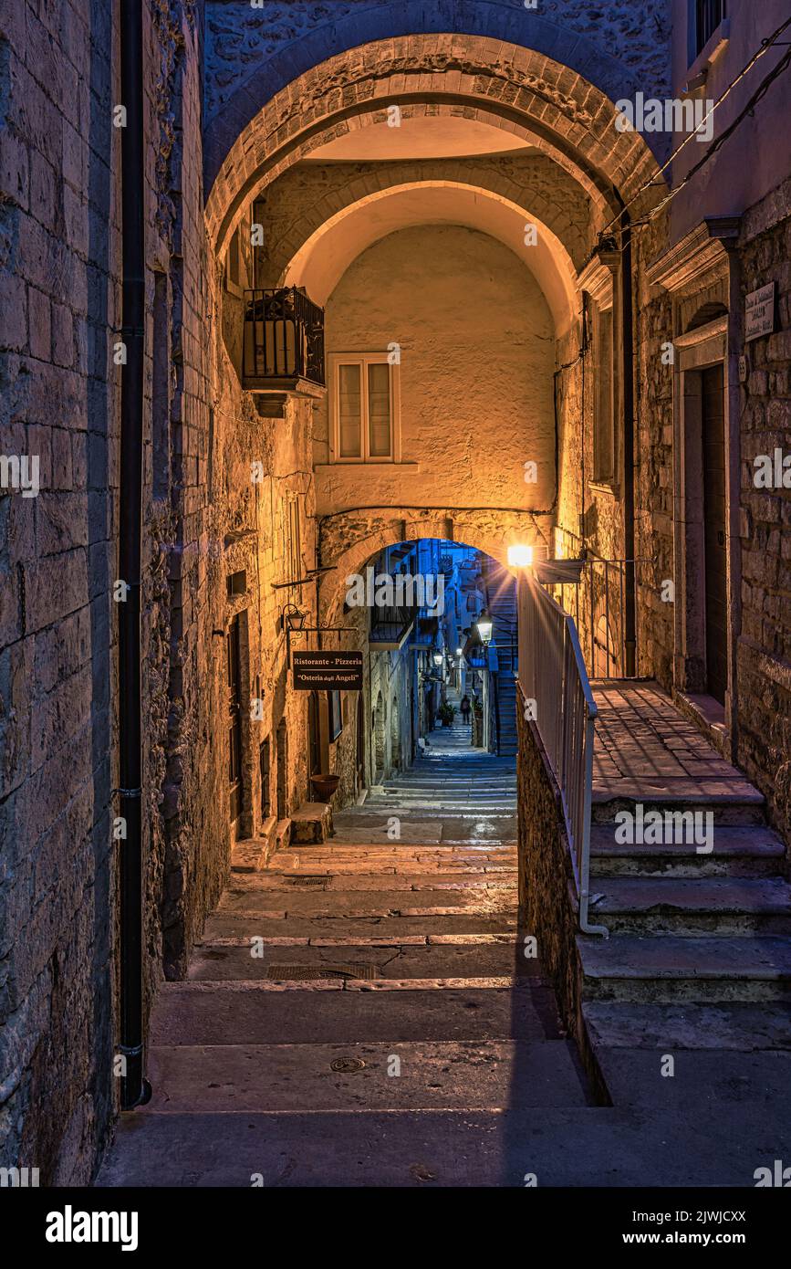 Charakteristische Gasse mit der klassischen Treppe der Stadt Vieste in den frühen Abendstunden. Vieste, Provinz Foggia, Apulien, Italien, Europa Stockfoto