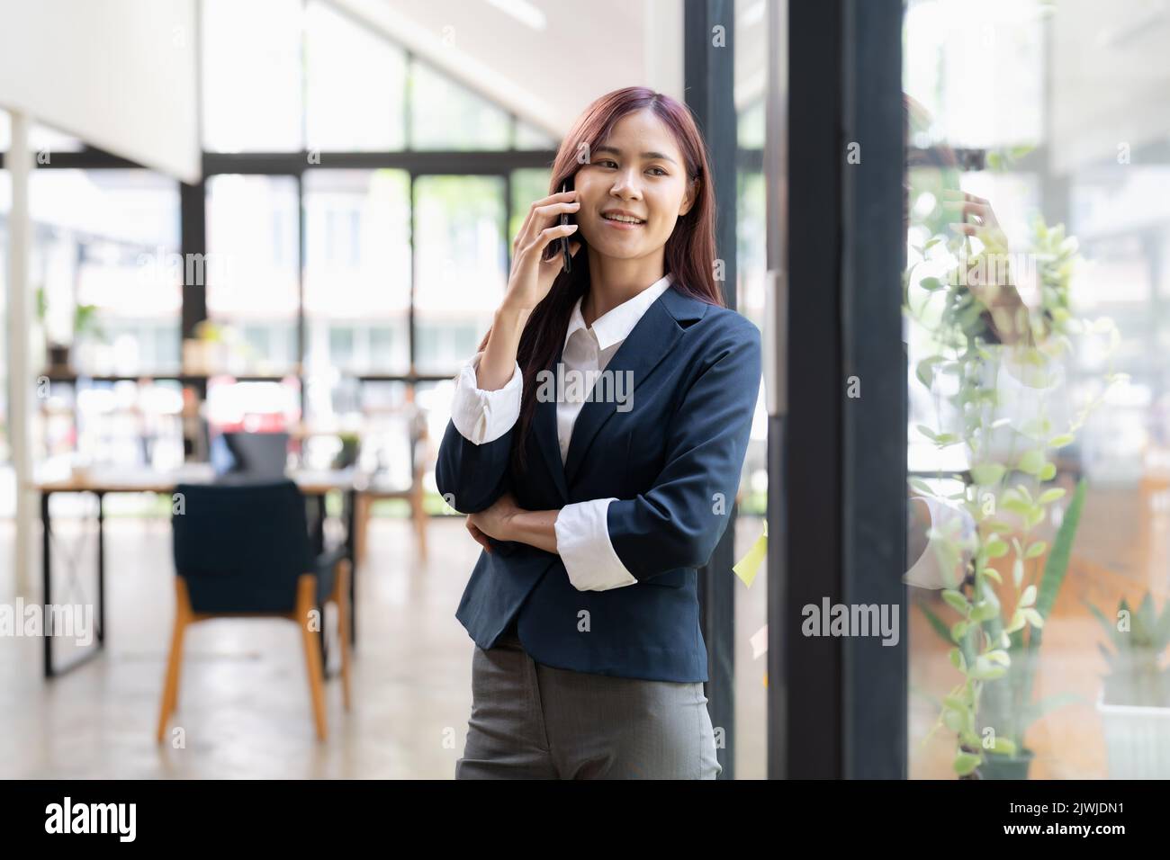 Asiatische weibliche stehend Telefongespräch mit Client und lächelnd. Stockfoto