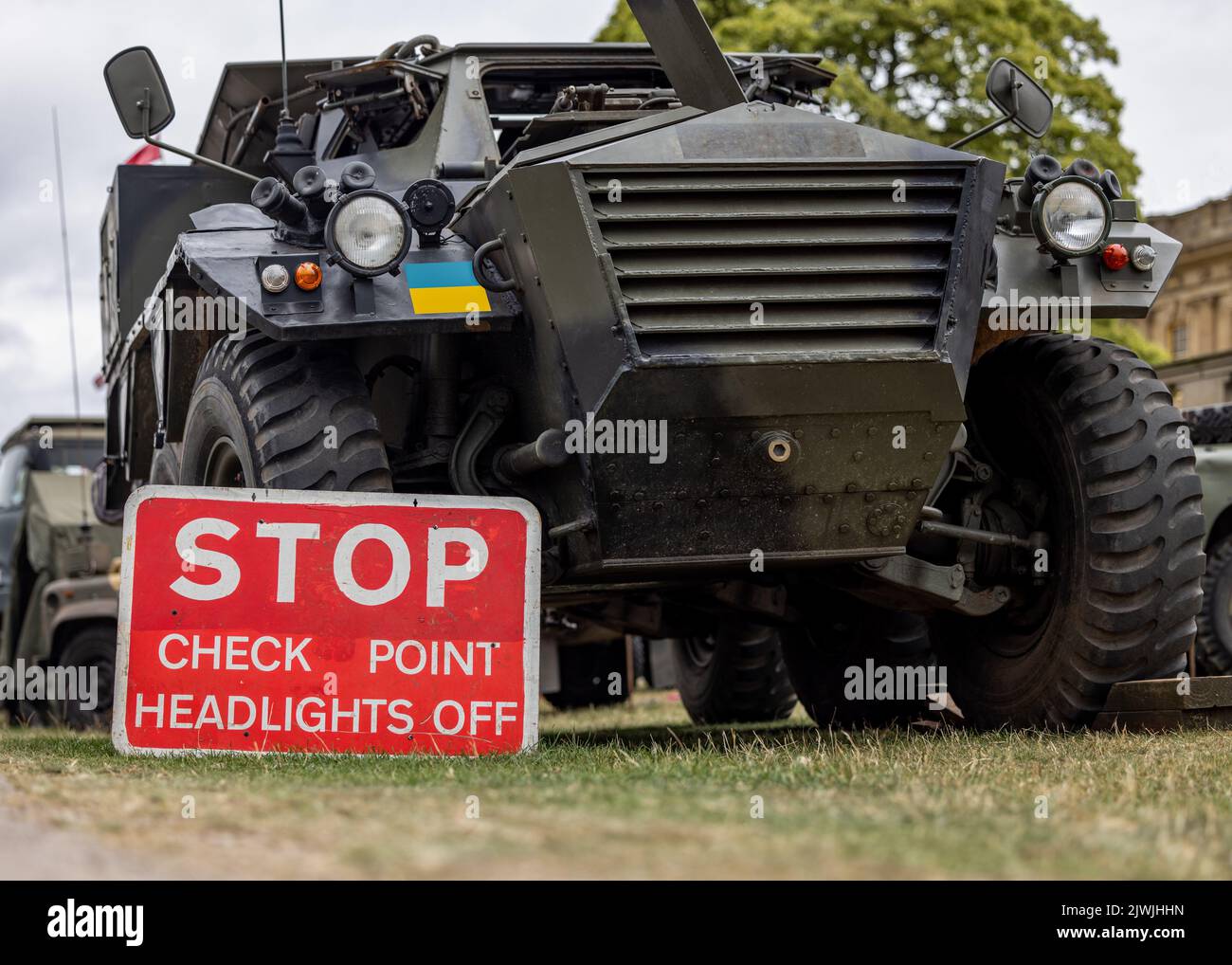 Ukrainischer Militärkontrollpunkt mit Panzerpanzerwagen an der Grenze der Ukraine. Stopp Kontrollpunkt rotes Schild Armee Ausrüstung. Stockfoto