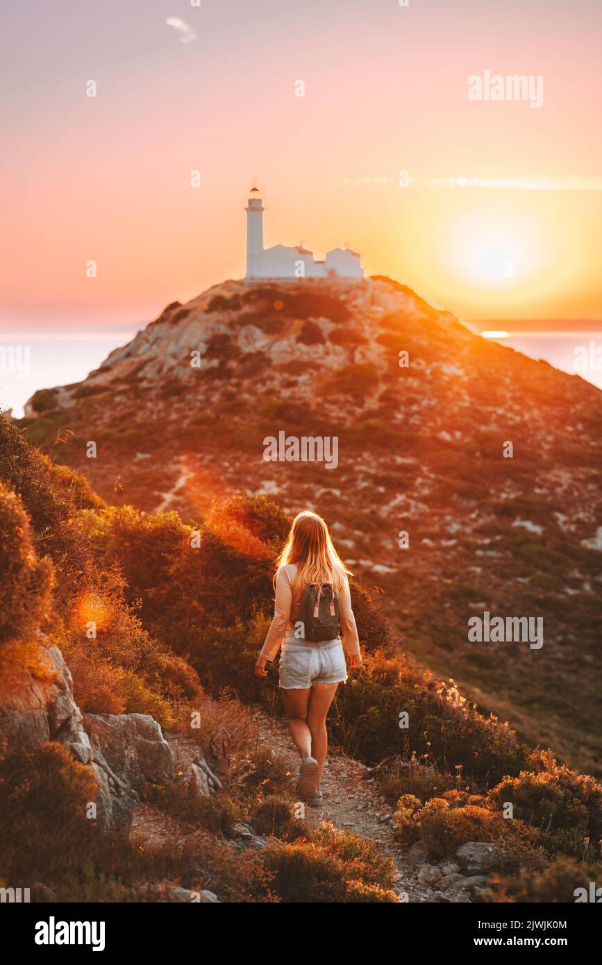 Frau Reisende Wandern zu Leuchtturm Reise gesunde Lebensweise aktive Sommerferien Outdoor-Mädchen mit Rucksack genießen Sonnenuntergang Blick in der Türkei Stockfoto