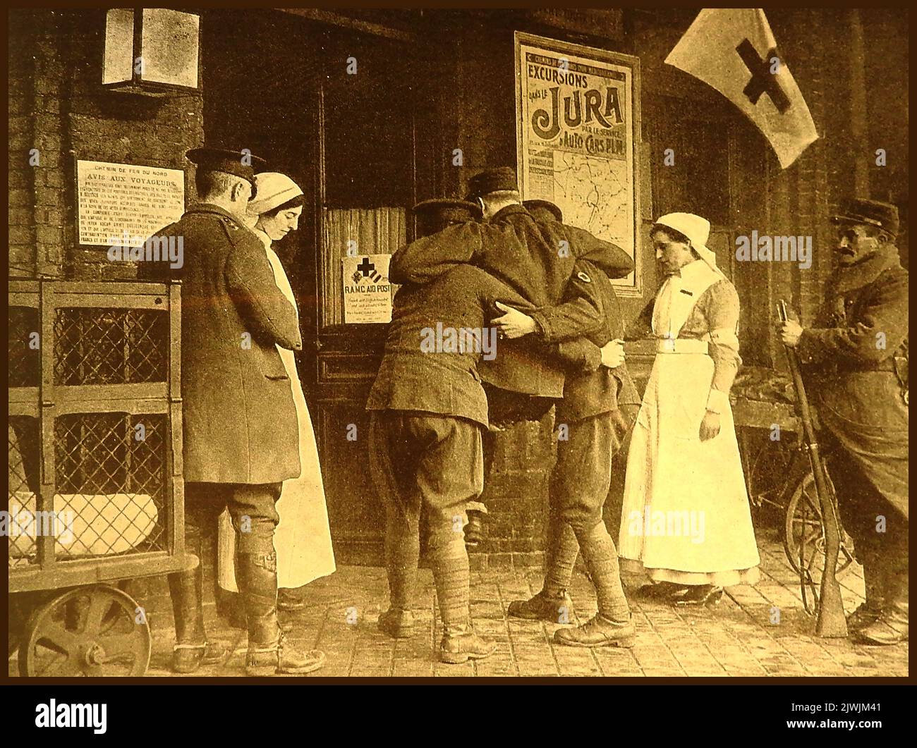 WWI - R.A.M.C. Mitarbeiter des Royal Army Medical Corps tragen den ersten verwundeten Soldaten in die erste „Aid Post“ des Roten Kreuzes in Frankreich, die sich in Räumlichkeiten befindet, die früher von AVIS-Motoren für Exkursionen genutzt wurden Stockfoto
