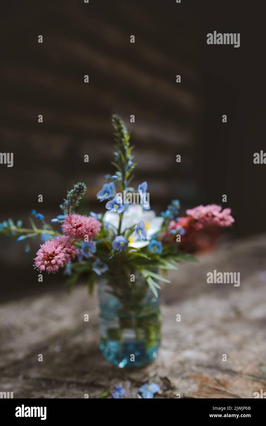 Wilde Blumen in Vase auf Holztisch gemütliche Einrichtung rustikalen Stil Dekoration Landschaft zu Hause Stockfoto