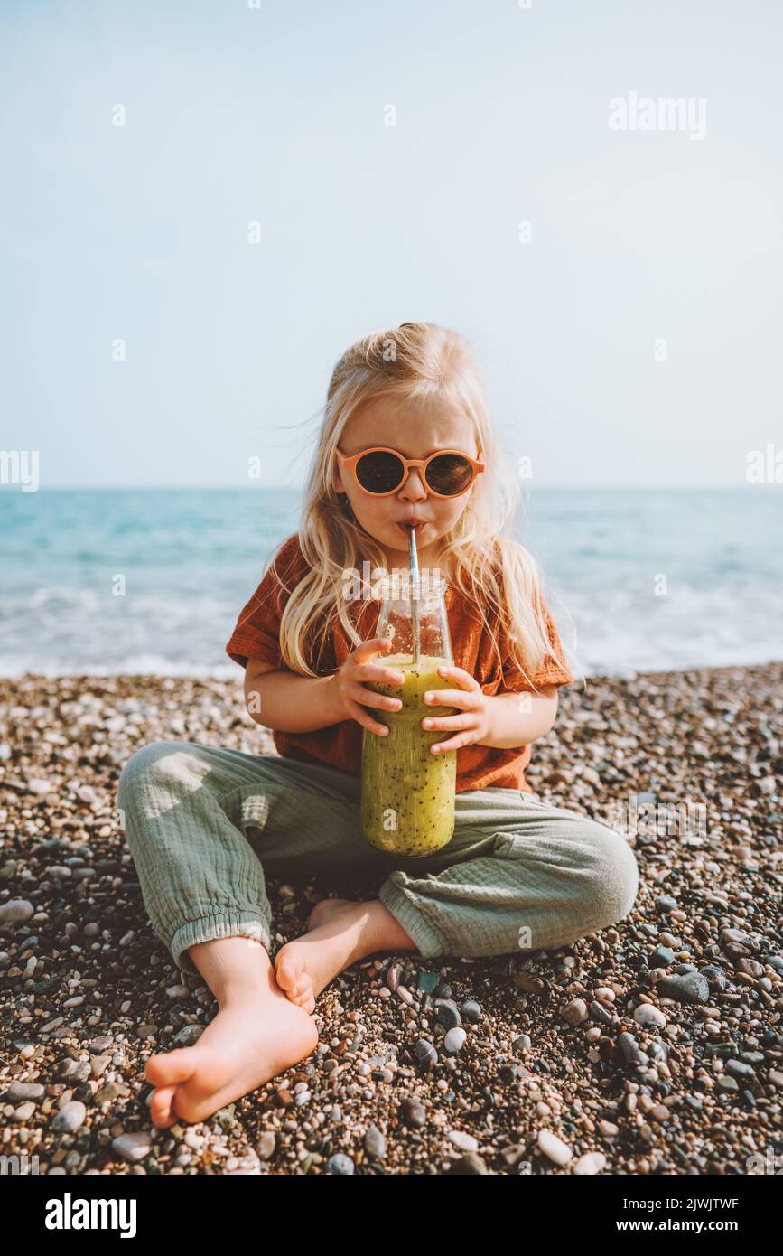 Picknick am Strand Kinder trinken Smoothie mit Glasflasche gesunder Lebensstil veganes Essen Detox Getränk Sommerreise Familienurlaub Stockfoto