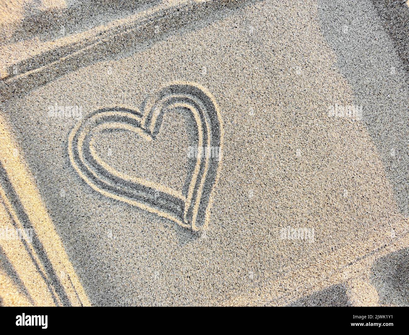 Herz in einem Rahmen auf den Sand gezeichnet, Draufsicht, Nahaufnahme. Speicherplatz kopieren. Stockfoto