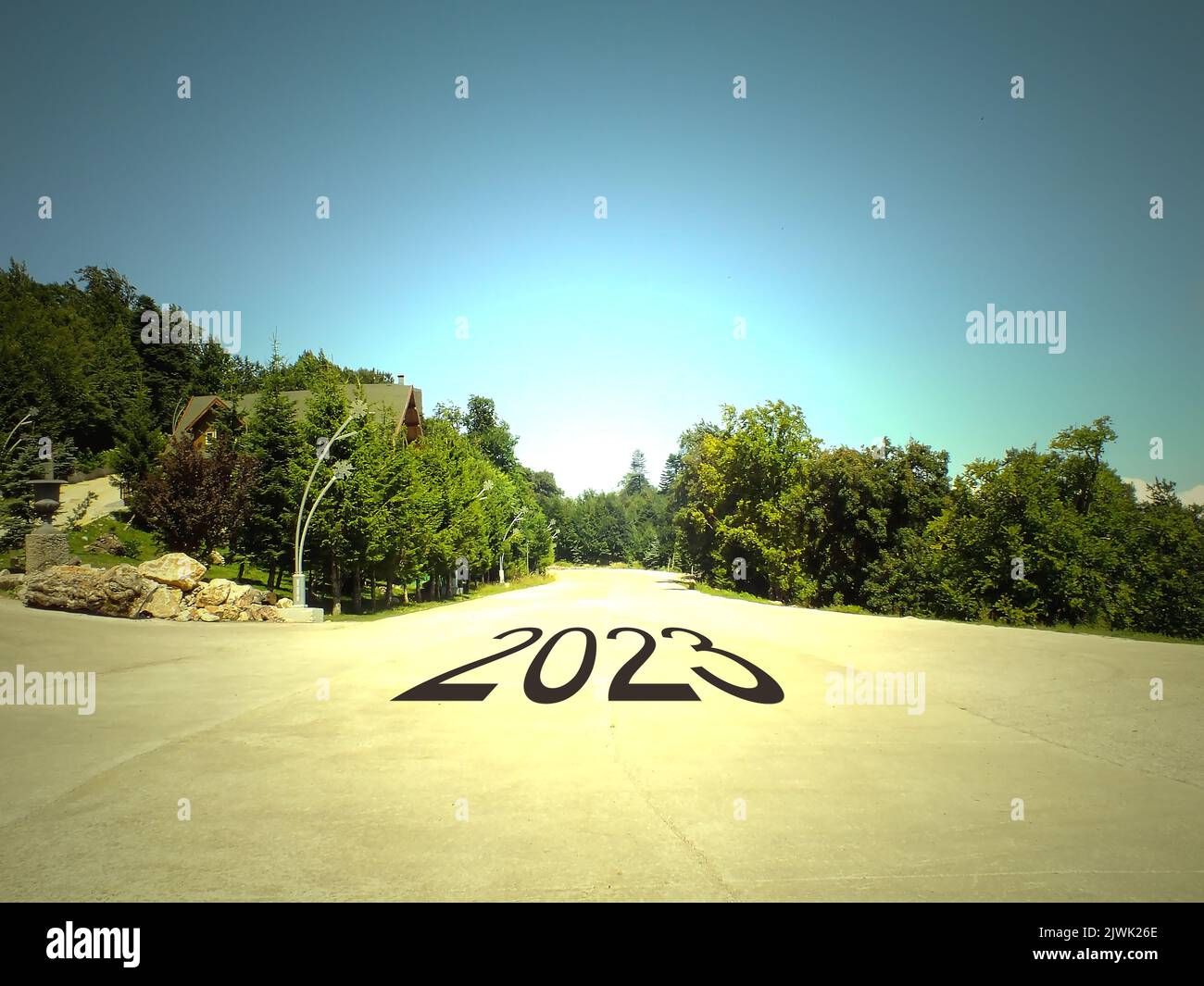 2023 geschrieben auf einer Straße inmitten einer leeren Straße und einer wunderschönen Landschaft. Konzept für die Vision des neuen Jahres 2023. Stockfoto